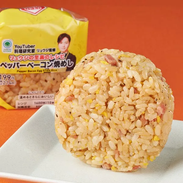 ペッパーベーコン焼めしの写真。白い皿の上に丸く盛り付けられており、パッケージが背景に写っている。