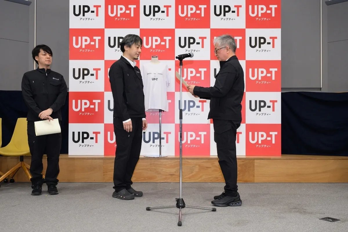 プレゼンテーションをするひろゆきとUP-Tのロゴ